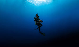 Diver with underwater camera set up scuba diving.